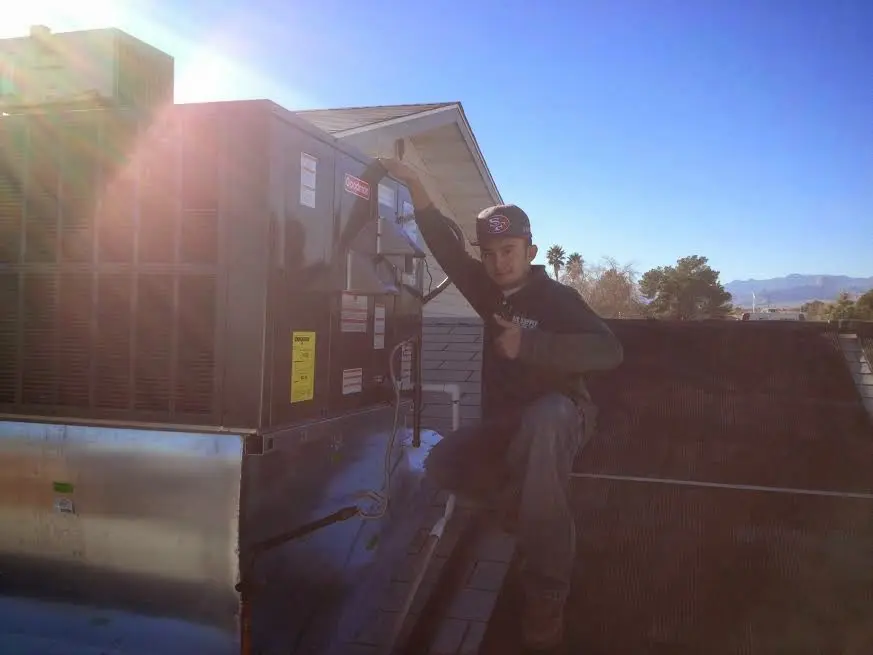 HVAC technician performing AC Tune-Up on a rooftop unit in Inverness